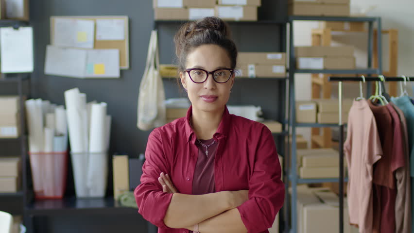 Medium arc shot of female manager posing for camera with arms crossed during workday in delivery service office - Powered by Shutterstock - Get 15% off with code: PIKWIZARD15