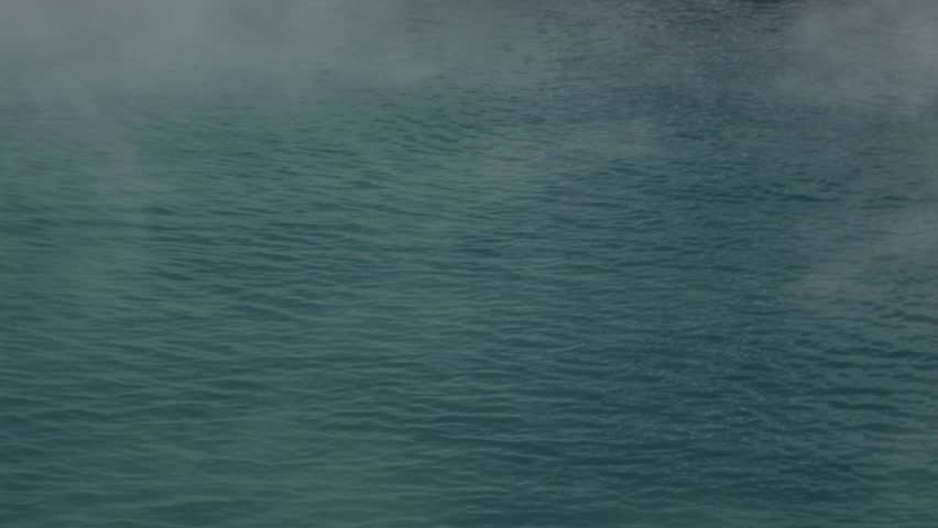 Clouds of steam rising from hot spring
