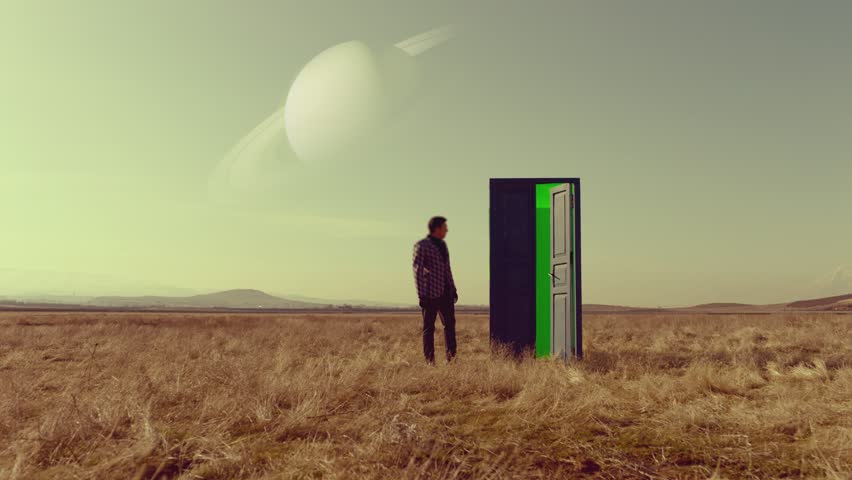 Footage of man walking on field near door with green screen . Young stylish male artist standing on meadow field at day time . Concept of fantasy mystic dreams or teleportation. Another Dimension Royalty-Free Stock Footage #1098373581