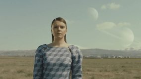 Portrait of woman walking on field . Surreal extraterrestrial landscape . Surface of earth with planets in the cloudy sky . Moon at day . Concept of mystic dreams . Approach of two nearby planets