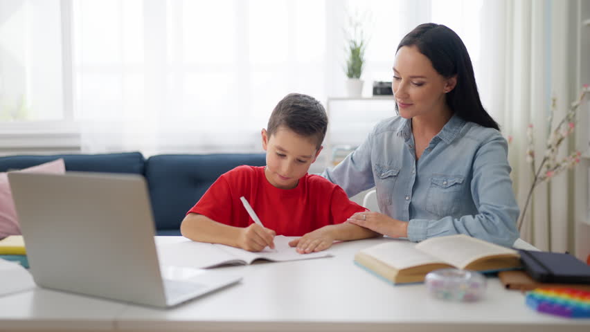 Mom and son high fiving each other after completing school assignment, teamwork Royalty-Free Stock Footage #1098374499