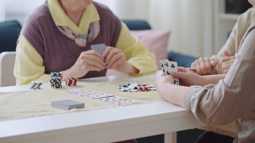 Senior woman going all in during poker game with friends, pushing chips forward | Shutterstock HD Video #1098374603
