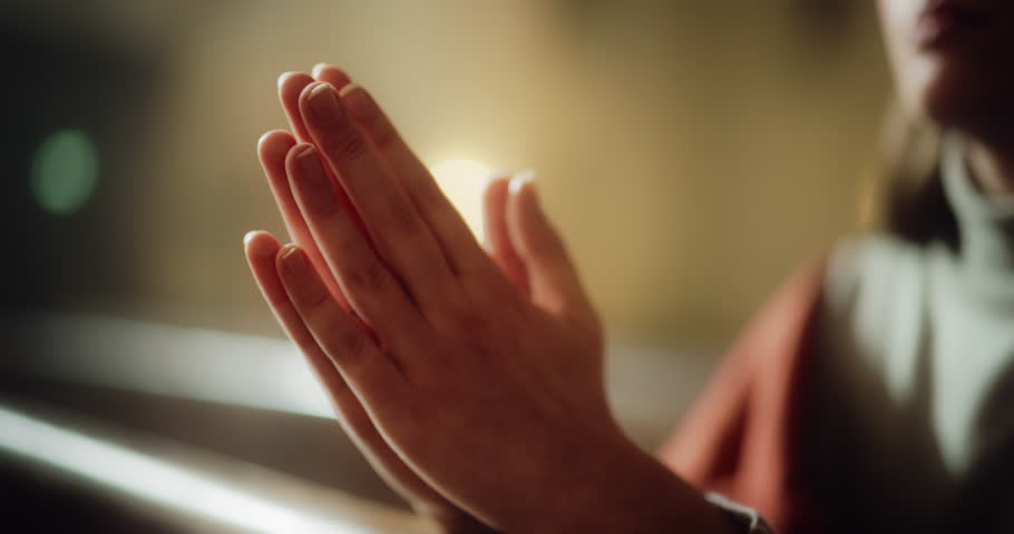 Christian Woman Sits Piously in Church, Praying, Seeks Guidance and Solace from Religious Faith and Spiritual Belief in God. Cinematic Camera Moving from her Praying Hands to her Hopeful Face Royalty-Free Stock Footage #1098381243