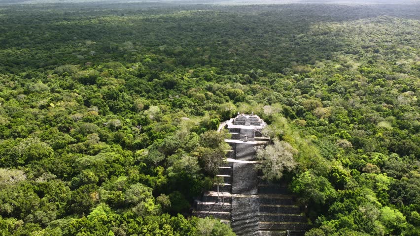 The ruins of the ancient Mayan city, the Mayan pyramid Calakmul surrounded by jungle. Aerial view of the Mexican pyramids Royalty-Free Stock Footage #1098382251