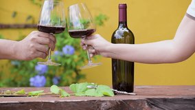 Hand hold glass to cheering and Drink glasses of red wine. Red wine pouring from bottle by winemaker to clear glass in vineyard vintage barrel winery. Pouring red wine into goblet on wood table  - Powered by Shutterstock - Get 15% off with code: PIKWIZARD15