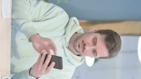 Vertical Video of Young Adult Man Talking on Phone