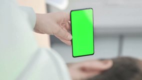 Vertical Video of Young Adult Man Holding Horizontal Smartphone with Green Screen