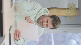 Vertical Video of Young Adult Man Reading Documents in Office