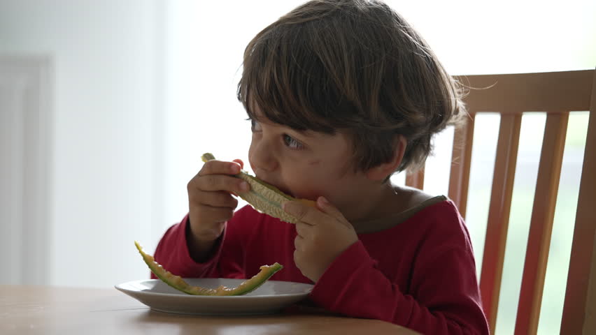 One small boy eating fruit snack in morning breakfast