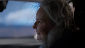Portrait of beautiful 60s mature senior grey haired Caucasian female riding in a car on a passenger seat with opened window - Powered by Shutterstock - Get 15% off with code: PIKWIZARD15