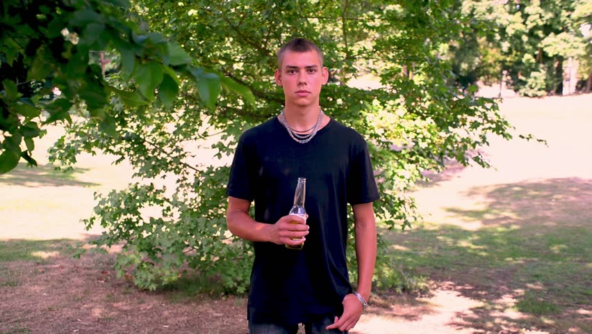 young guy drinking beer on the street