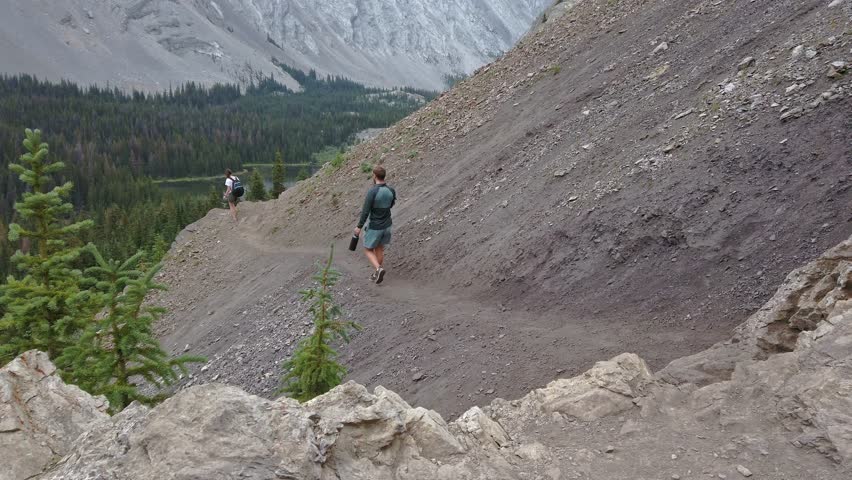 Hiker on trail in Mountain taking photographs Kananaskis Alberta Canada