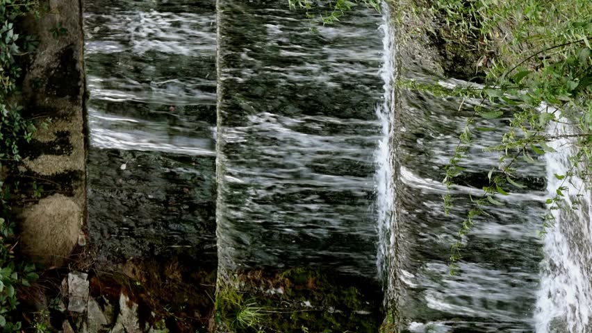Small cascade waterfall with strong currents pouring down in beautiful park Alexandria in Bila Tserkva city at Ukraine. Vertical video. Close-up.