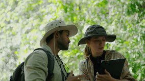 couple biologist on a forest walk collecting data is using binoculars to look into the treetops, conservation concept, green, environment. - Powered by Shutterstock - Get 15% off with code: PIKWIZARD15