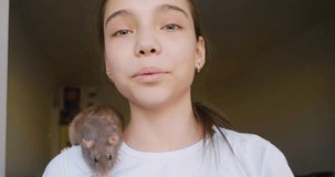 A teenage girl talks about her pet, a domestic rat, during an online broadcast. She talks about the features of caring for domestic rodents. Close-up 4k footage.