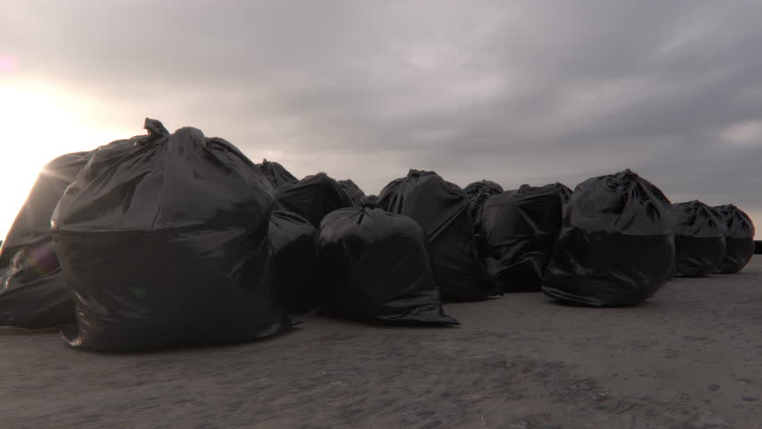 Group of Black Plastic Garbage bags trash on the ground with sunset light background. Slow motion. 4K
 Royalty-Free Stock Footage #1098414867