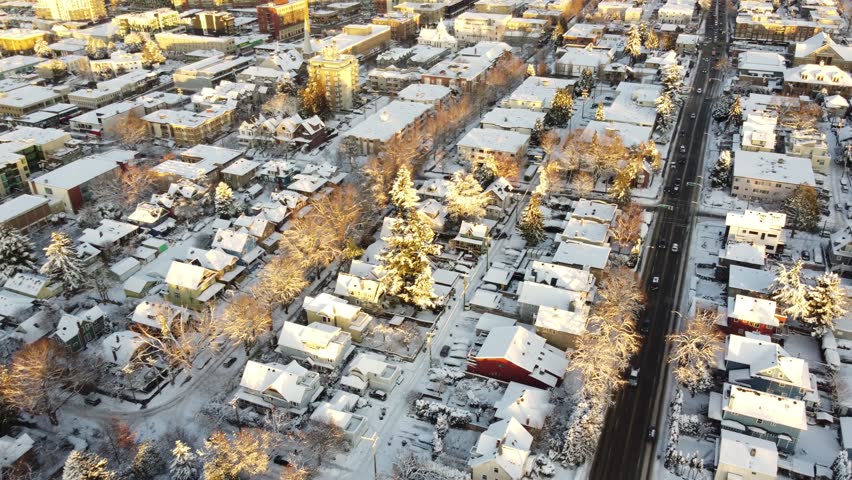 Aerial view of snowy roofs and black roads during winter in Vancouver
