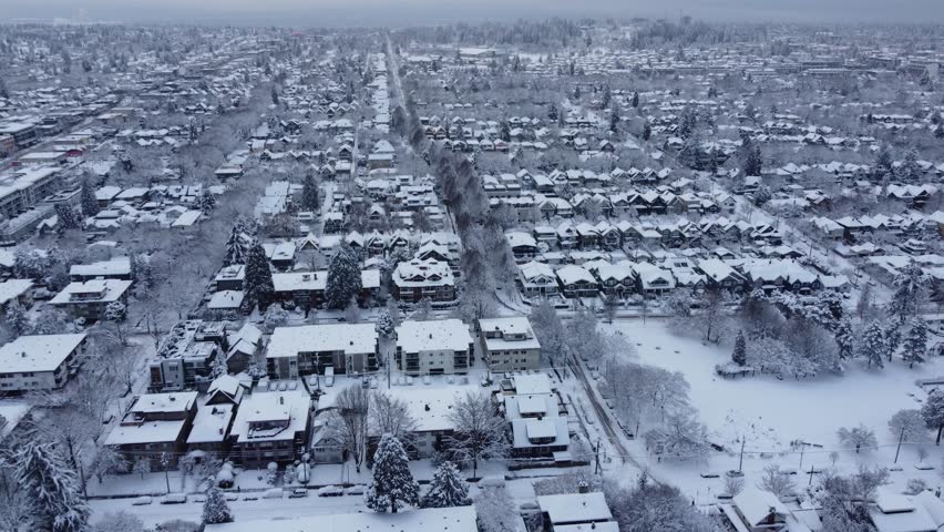 Sleepy neighbourhood in Vancouver with small houses and roofs under fresh snow
