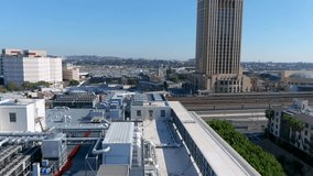ascending tilt footage of office buildings and apartments in the city skyline with railroad tracks in Los Angeles California USA
