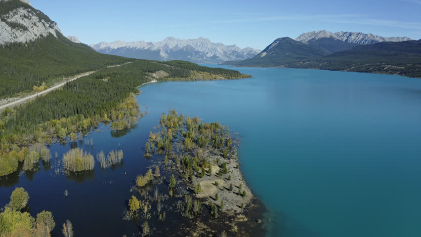Aerial descent towards calm waters of Abraham Lake, autumn, Alberta, Canada.