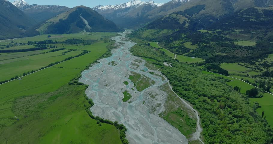 Natural glacier river flowing through lush green valley in New Zealand, Rees
