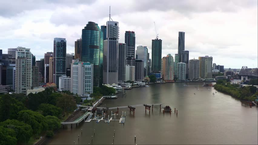 Cinematic dynamic zoom in aerial shot of riverside downtown cityscape at central business district cbd, densely populated with corporate office buildings, Brisbane city, Queensland, Australia.