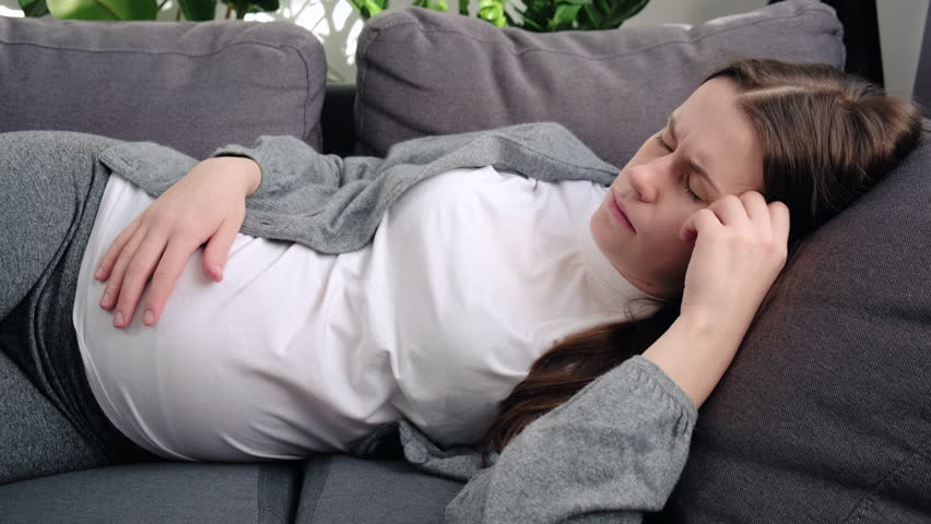 Unhappy tired young pregnant woman suffering from headache or negative thoughts, worrying about bad prenatal screening tests results, lying on couch at home. Feeling fear of childbirth concept Royalty-Free Stock Footage #1098439789