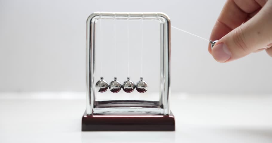 Swinging spheres or a Newton's cradle, device that demonstrates the conservation of momentum and the conservation of energy. Royalty-Free Stock Footage #1098440457