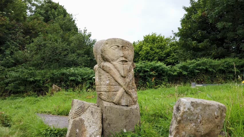 This is a bronze age stone carviing with two faces,called Janus, located In Caldragh Cemetery on Boa Island, Lower Lough Erne. Northern Ireland Royalty-Free Stock Footage #1098441595