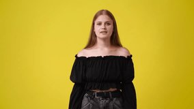 4k slow motion of one girl gesturing no over yellow background.