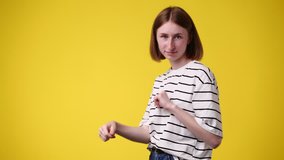 4k slow motion video of girl dancing on yellow background.