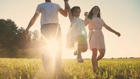 happy family running in the park. dad and mom silhouette throw up their daughter up holding hands run next outdoor to a dog in a park in nature. friendly family running together at sunset back view - Powered by Shutterstock - Get 15% off with code: PIKWIZARD15