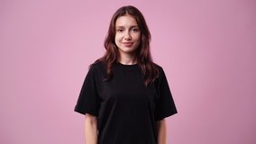 4k slow motion video of one girl posing for a video over pink background.