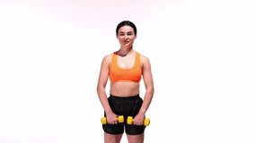 Young sportive girl training with dumbbells over white studio background. Training hands muscles. Modern sport, action, motion, youth concept. Fitness, hobby, healthy lifestyle