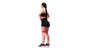 Complex exercises on legs and buttocks. Young sportive girl training with fitness elastic bands over white studio background. Squats. Sport, motion, youth concept. Fitness, hobby, healthy lifestyle