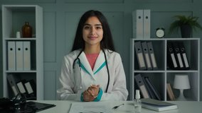 Happy young woman doctor medic looking at camera use virtual video connection consulting patient online share news congratulating good health test results give support clapping hands ovation gesture