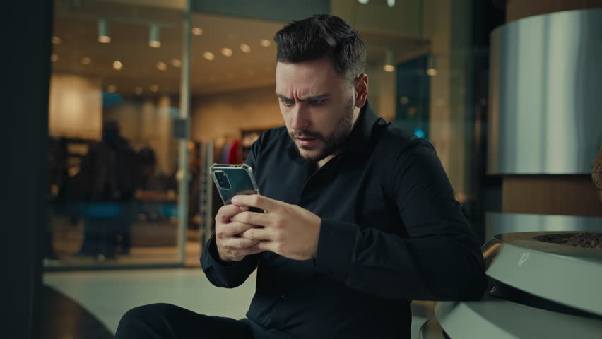 Disappointed upset annoyed man businessman male employee use phone gadget read bad notification wrong data mobile error business problem electronic fraud e-banking debt receive unpleasant news e-mail | Shutterstock HD Video #1098449515