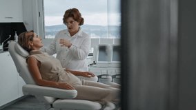 Woman cosmetologist dermatologist talking with client sitting comfortable chair salon. Aesthetic specialist consulting lady advising rejuvenation procedure plastic surgery. Professional examination. - Powered by Shutterstock - Get 15% off with code: PIKWIZARD15