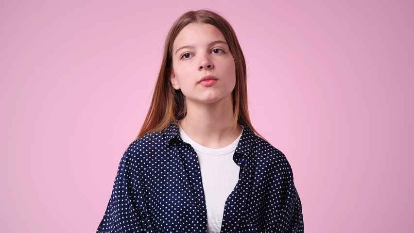 4k slow motion video of girl with thoughtful facial expression on pink background. | Shutterstock HD Video #1098465433