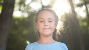 Happy child. Cute blonde girl looks at camera in park girl smiles. Happy child in park. Summer holidays in park. Child on walk smiling at camera. blonde kid - Powered by Shutterstock - Get 15% off with code: PIKWIZARD15