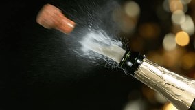 Super slow motion of Champagne explosion with flying cork closure, gold colors, opening champagne bottle closeup. - Powered by Shutterstock - Get 15% off with code: PIKWIZARD15