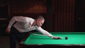 a man hits a red ball with a cue in billiards. High-quality FullHD video recording. real-time video