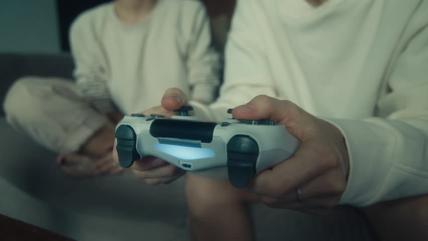 Two young women playing a video game on the couch in their home