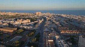 Aerial footage of calm Spanish city residential area landscape with a sea in a background. Sunset time. Drone footage. Vacation destination. City from the bird eye view. Torrevieja, Spain