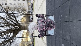 One girl toddler two years old playing on the swing in town city in winter or autumn day UGC user generated content vertical authentic video real people