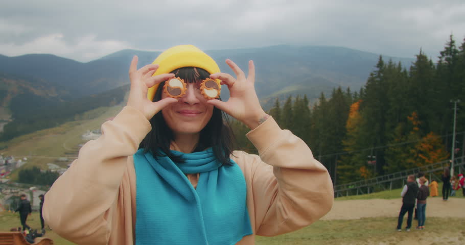 young woman traveler in the mountains warms up with a hot drink. autumn adventures. Generation Z travel