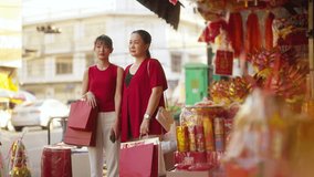 Asian mother and daughter using navigator on mobile phone while shopping home decorative ornaments and joss paper for celebrating Chinese Lunar New Year festival together at Chinatown street market. - Powered by Shutterstock - Get 15% off with code: PIKWIZARD15
