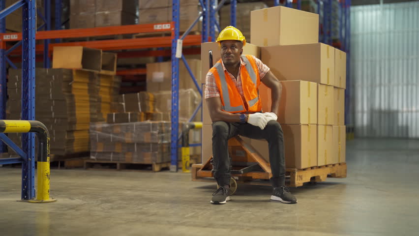 Portrait of black man worker working in large warehouse retail store industry factory. Rack of stock storage. Cargo in ecommerce and logistic concept. Depot. People lifestyle. Shipment service. | Shutterstock HD Video #1098505855