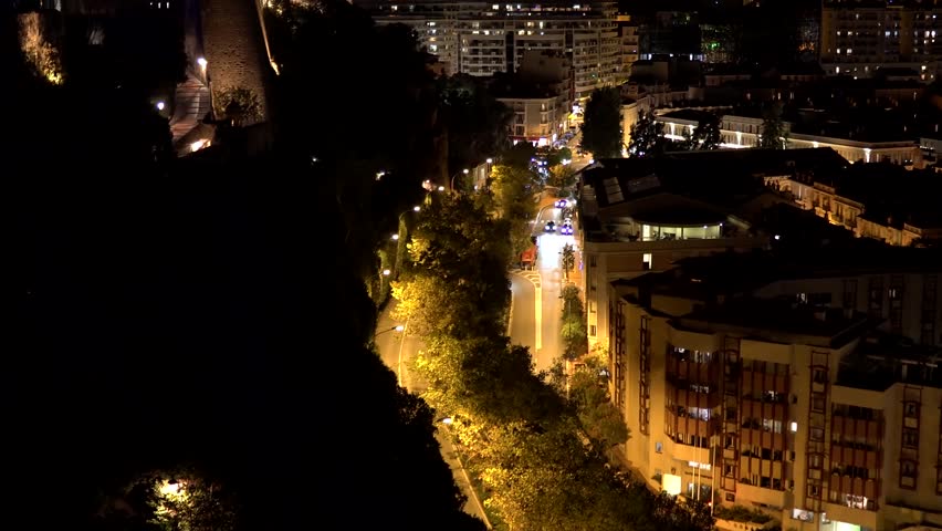 Night view of Monaco. Colorful houses and streets in Monaco. Monaco city and tiny state on the Mediterranean coast. Transport on the road near the promenade in Monaco
