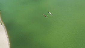 Canoeing competition on the river. Two boats are sailing on the river. Drone video in 4k